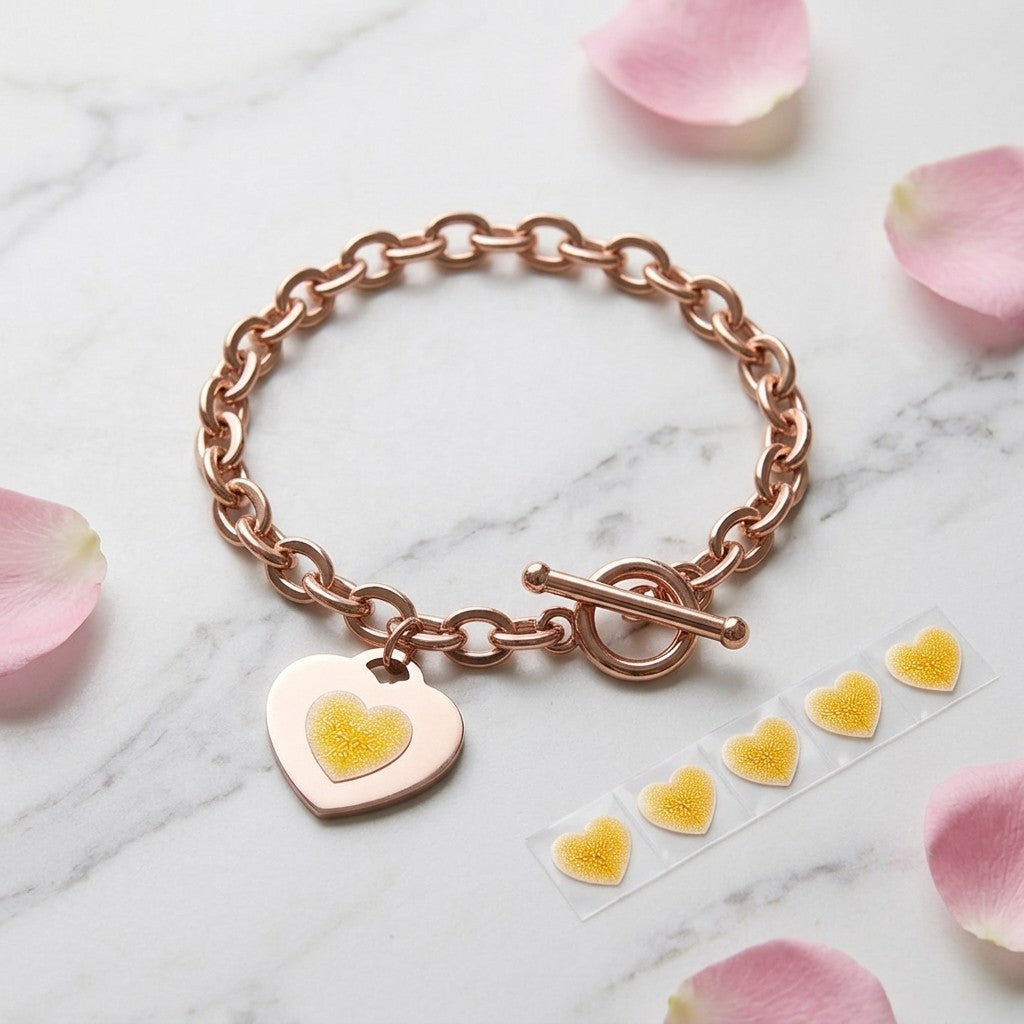 No Lace rose-gold charm bracelet with a yellow heart test sticker on its heart tag, and a strip of refill stickers